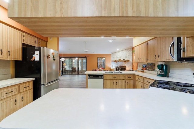 kitchen featuring light brown cabinetry, appliances with stainless steel finishes, sink, kitchen peninsula, and backsplash