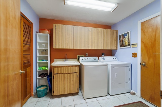 washroom with sink, washing machine and dryer, cabinets, and light tile patterned flooring