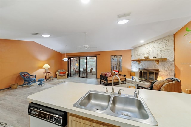 kitchen featuring dishwasher, decorative light fixtures, a fireplace, sink, and vaulted ceiling