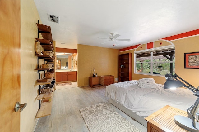 bedroom with ceiling fan, connected bathroom, and light hardwood / wood-style flooring