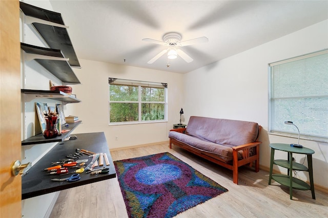 living area featuring light hardwood / wood-style floors and ceiling fan