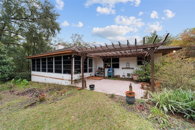 rear view of property with a lawn, a sunroom, a patio, and a pergola