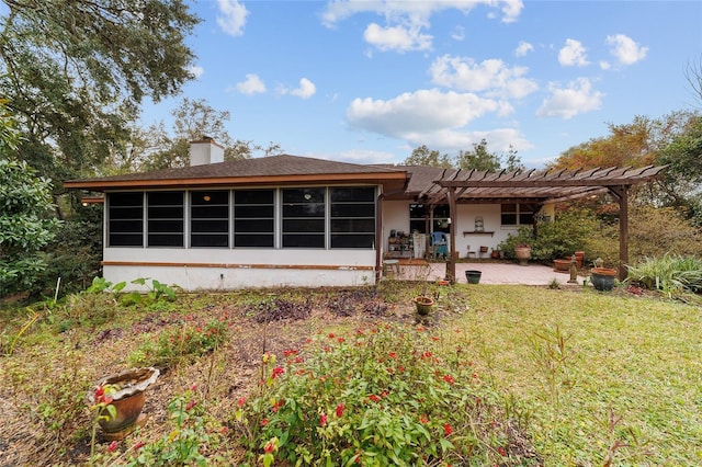 rear view of property with a patio, a pergola, a lawn, and a sunroom