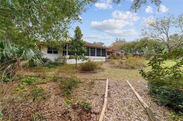 view of yard featuring a sunroom and a pergola