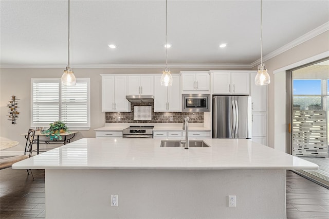 kitchen with hanging light fixtures, appliances with stainless steel finishes, sink, and white cabinets