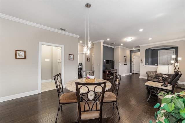 dining area with crown molding and dark wood-type flooring