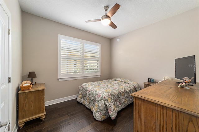 bedroom featuring ceiling fan, dark hardwood / wood-style flooring, and a textured ceiling