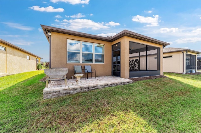 rear view of property with a patio, a sunroom, and a yard