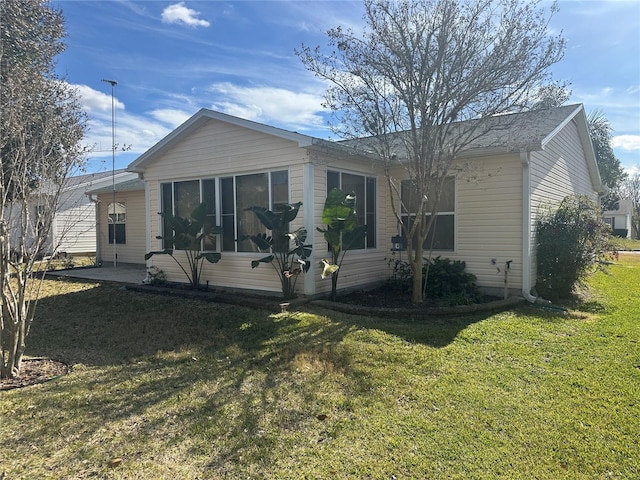 back of property with a yard and a sunroom