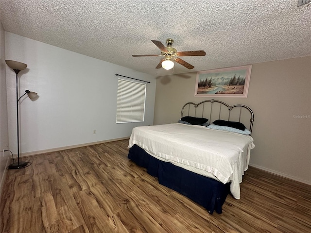 bedroom with wood-type flooring, a textured ceiling, and ceiling fan