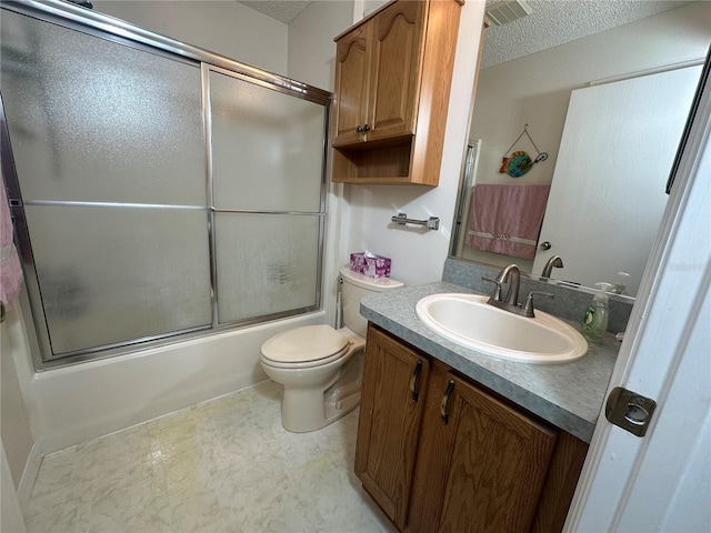 full bathroom featuring vanity, bath / shower combo with glass door, toilet, and a textured ceiling