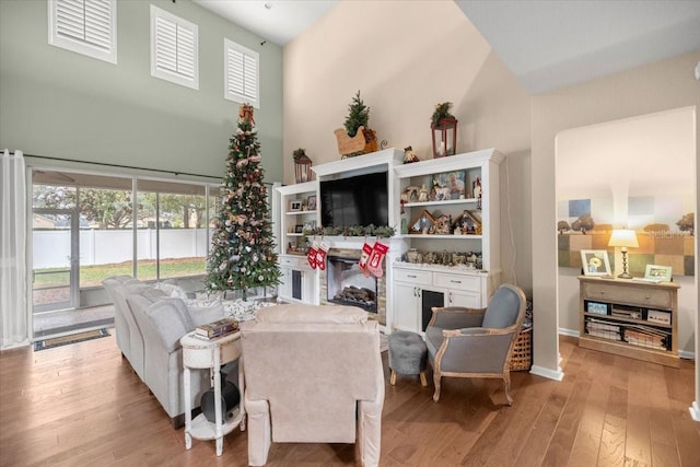 living room featuring light hardwood / wood-style flooring and a towering ceiling