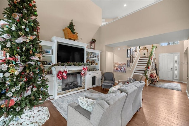 living room with hardwood / wood-style floors and a towering ceiling