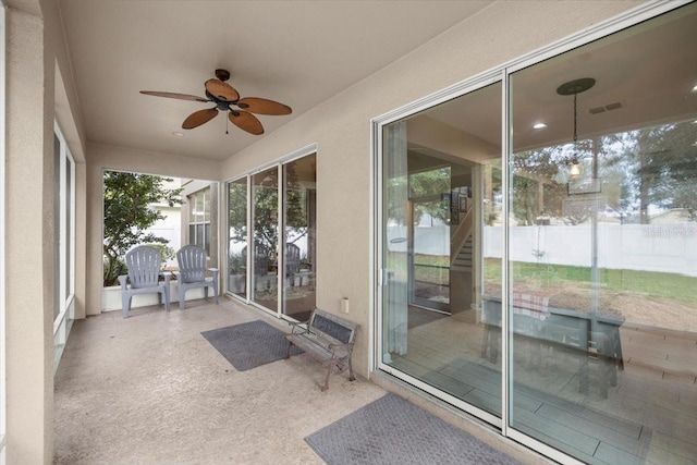 unfurnished sunroom with ceiling fan