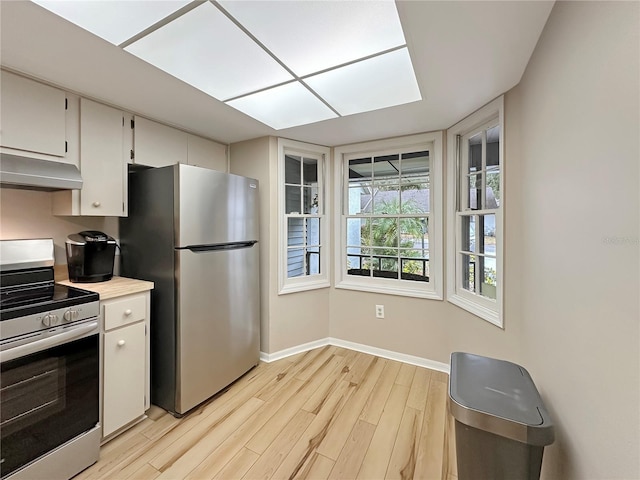 kitchen featuring white cabinets, light hardwood / wood-style floors, and appliances with stainless steel finishes