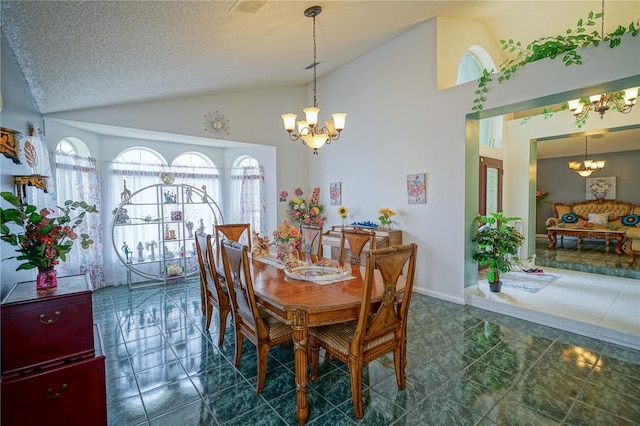 dining space featuring high vaulted ceiling, a textured ceiling, and an inviting chandelier