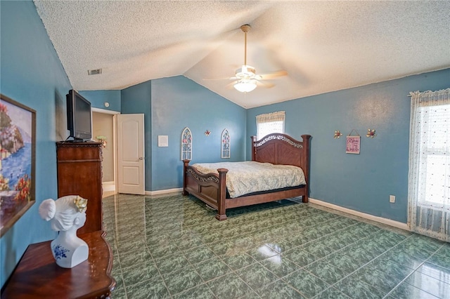 bedroom featuring ceiling fan, vaulted ceiling, and a textured ceiling