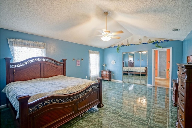 bedroom featuring ceiling fan, vaulted ceiling, and a textured ceiling