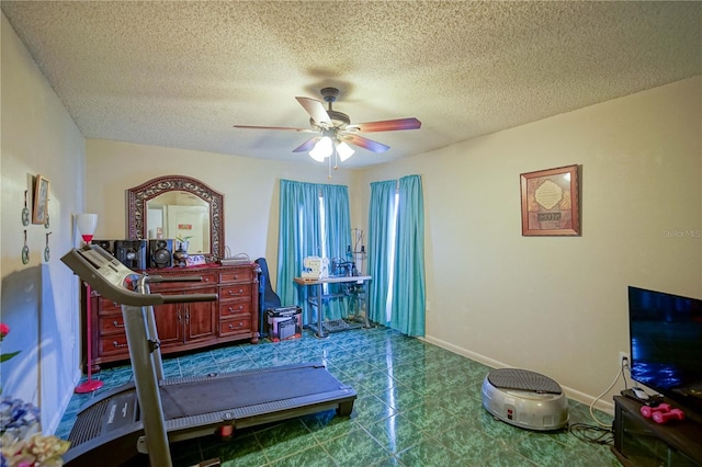 exercise room featuring a textured ceiling and ceiling fan