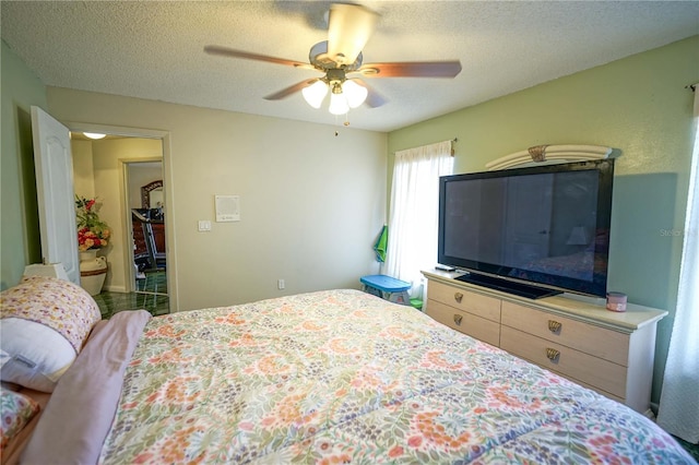 bedroom with ceiling fan and a textured ceiling