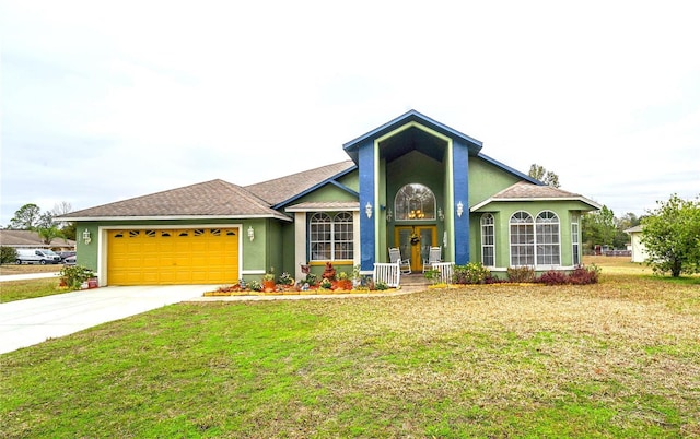 view of front of house with concrete driveway, a front yard, an attached garage, and stucco siding