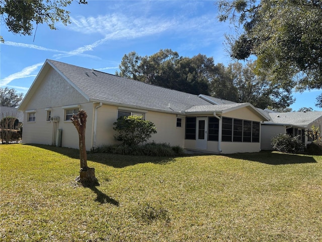 back of house featuring a yard and a sunroom