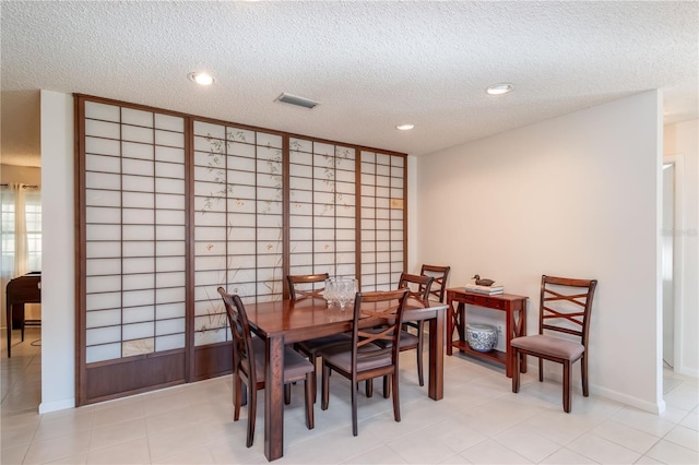 dining area featuring baseboards, visible vents, a textured ceiling, and recessed lighting