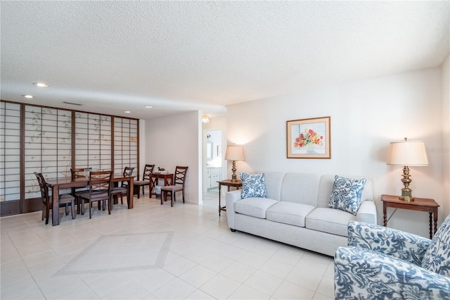 living area featuring a textured ceiling, light tile patterned flooring, and recessed lighting