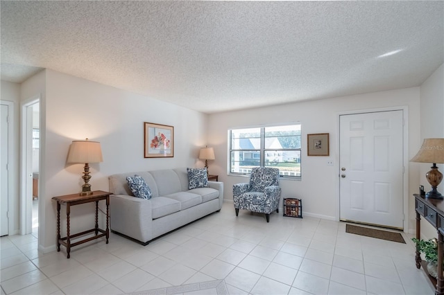 living room with light tile patterned flooring, a textured ceiling, and baseboards