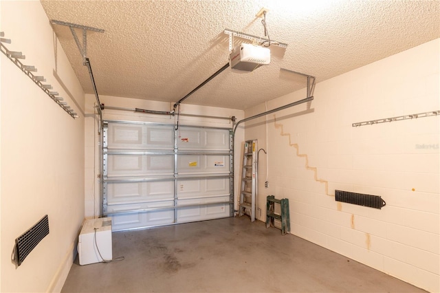 garage with concrete block wall and a garage door opener