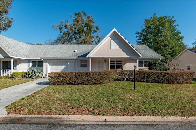 view of front of property featuring a garage, a front yard, driveway, and stucco siding