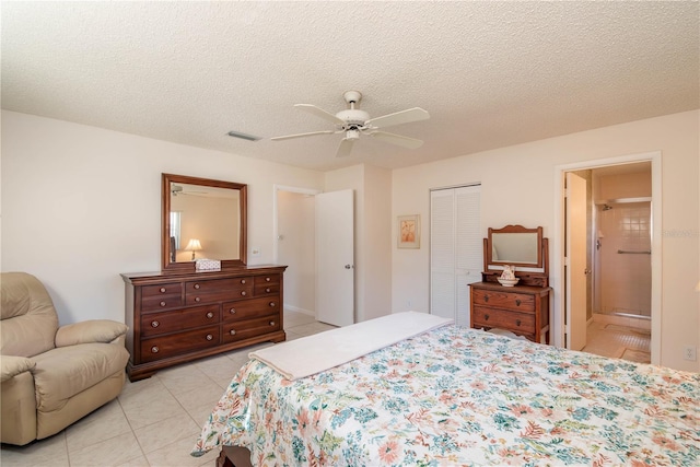 bedroom with a textured ceiling, a closet, light tile patterned flooring, and visible vents