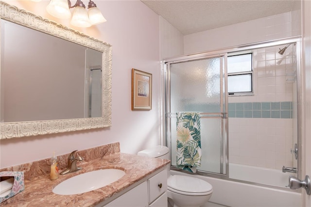 bathroom with toilet, shower / bath combination with glass door, a textured ceiling, and vanity