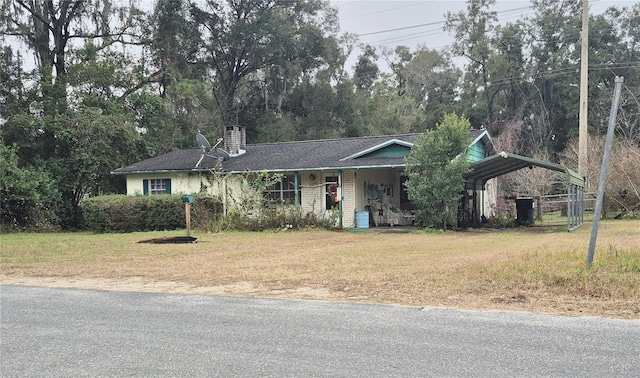 ranch-style home featuring a front yard and a carport