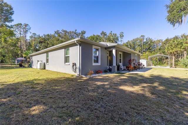 view of side of home featuring a lawn and a carport