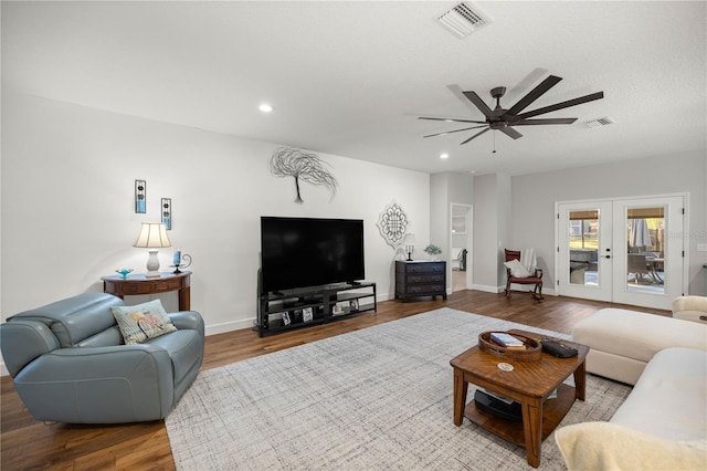 living room with ceiling fan, french doors, light hardwood / wood-style flooring, and a textured ceiling