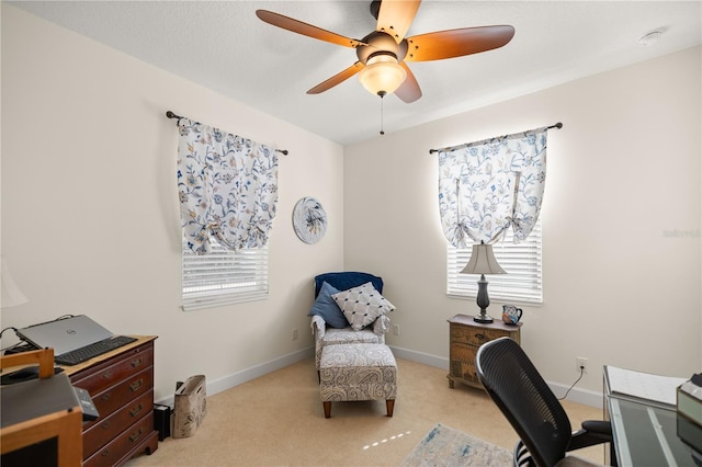 carpeted home office featuring ceiling fan