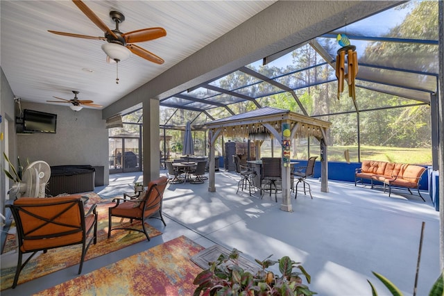 view of patio / terrace featuring glass enclosure, an outdoor hangout area, and ceiling fan