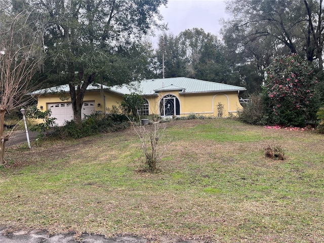 single story home with a garage and a front lawn