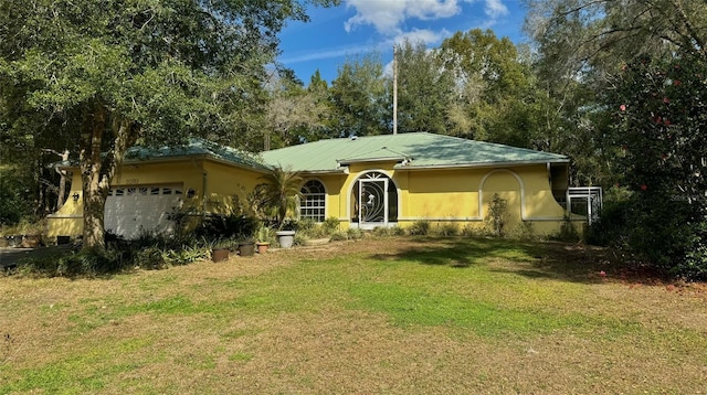 single story home with a garage and a front lawn