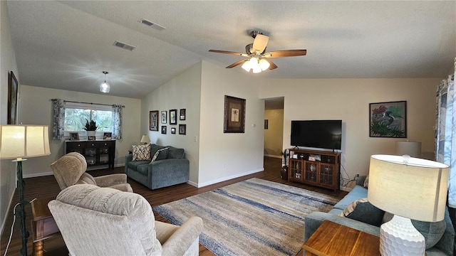 living room featuring ceiling fan, dark hardwood / wood-style flooring, vaulted ceiling, and a textured ceiling