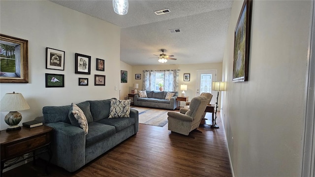 living room featuring lofted ceiling, ceiling fan, dark hardwood / wood-style floors, and a textured ceiling