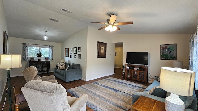 living room featuring visible vents, wood finished floors, a ceiling fan, and lofted ceiling