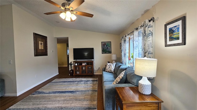 living area featuring a textured ceiling, wood finished floors, a ceiling fan, and vaulted ceiling