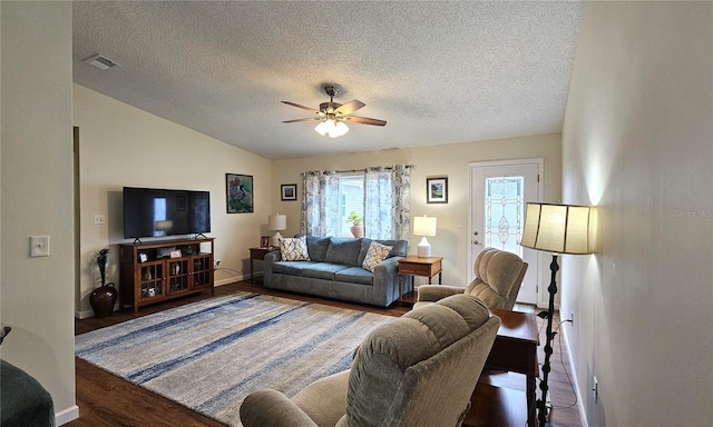 living room with ceiling fan, visible vents, baseboards, a textured ceiling, and wood finished floors