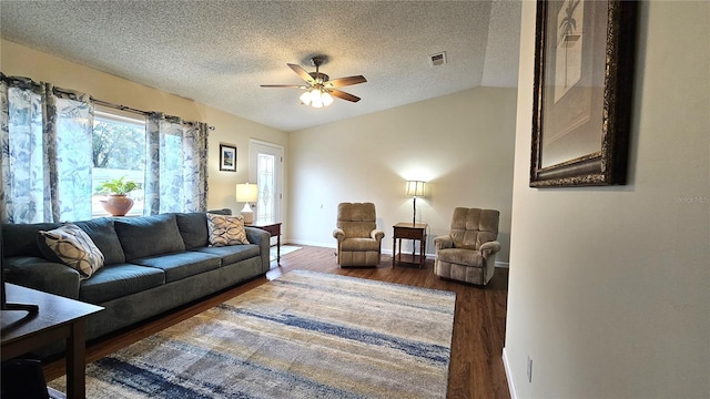 living room featuring wood finished floors, baseboards, visible vents, a ceiling fan, and a textured ceiling