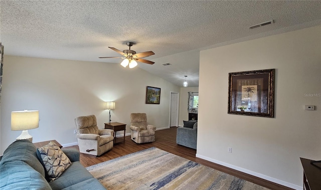 living room with ceiling fan, visible vents, baseboards, vaulted ceiling, and wood finished floors
