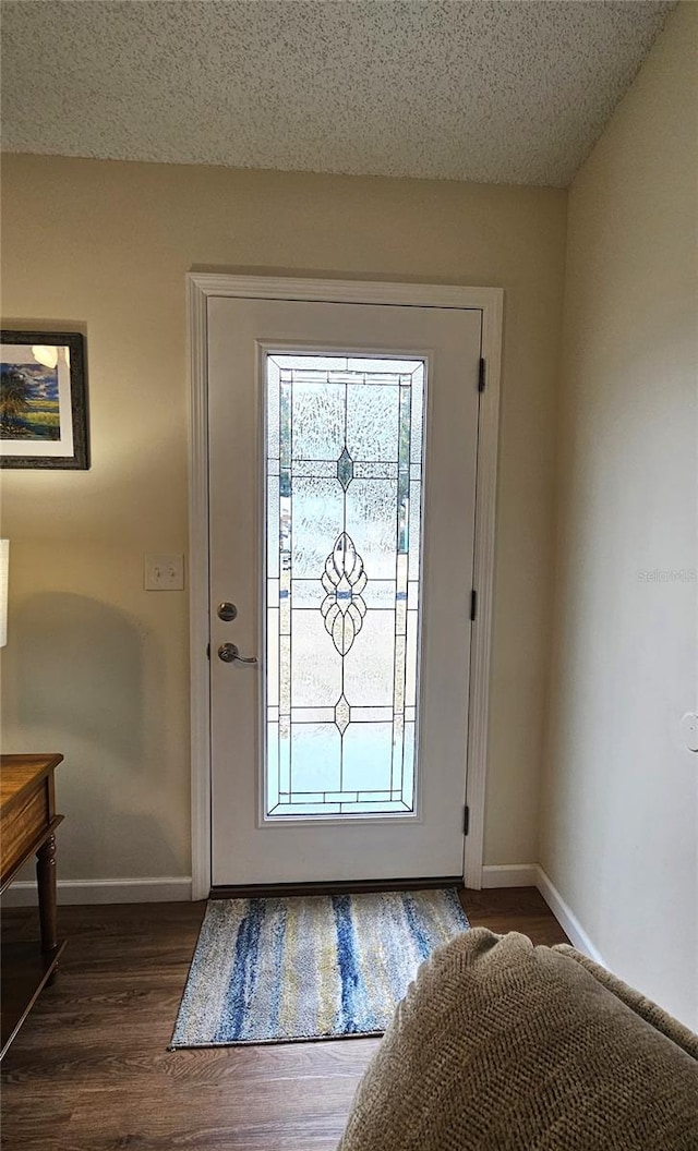 entryway with dark wood-type flooring and baseboards