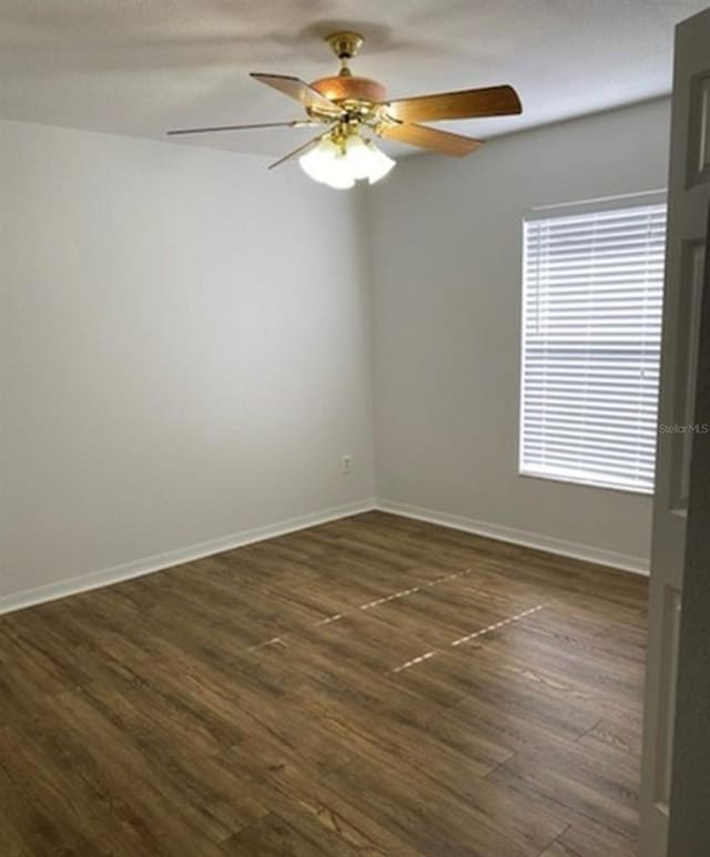 spare room featuring dark hardwood / wood-style floors and ceiling fan