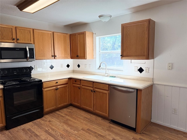 kitchen with hardwood / wood-style flooring, appliances with stainless steel finishes, and sink